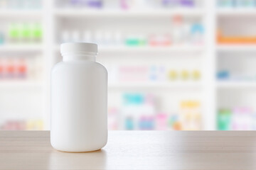White medicine bottle on wood counter with pharmacy drugstore shelves blur pharmaceutical background