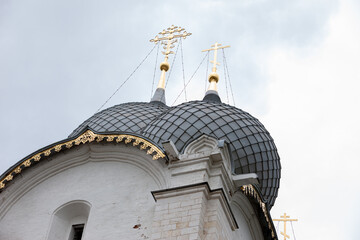 Traditional Russian churches domes made of grey scales and golden crosses  close up