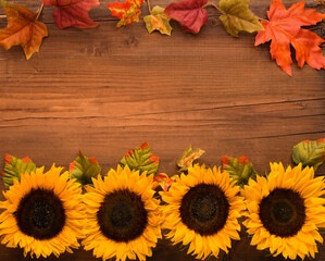 Sunflowers, dried leaves, pumpkins, apples and rowan berries on rustic wooden background. Autumn, fall, thanksgiving day concept.