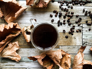 dry leaves and coffee on a wooden table