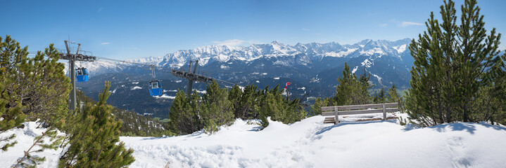 lookout point with bench, view to zugspitze mountain and Wank cable railway, bavarian alps, early...