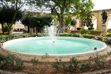 Fototapeta na wymiar The Barrakka Gardens in Valletta, Malta, with cozy benches and beautiful fountain are a great place for relaxation and promenade