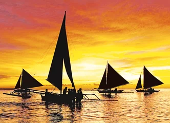 Photo sur Plexiglas Plage blanche de Boracay La silhouette de quatre voiliers au coucher du soleil le long de la plage blanche sur l& 39 île de Boracay, Aklan, Philippines. Le ciel a l& 39 air jaune orangé comme une boule de feu.