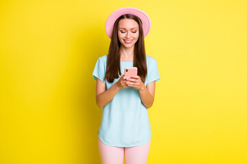 Photo of positive cheerful girl instagram blogger use smartphone follow subscribe news wear pink pants trousers stylish sunhat isolated over bright shine color background