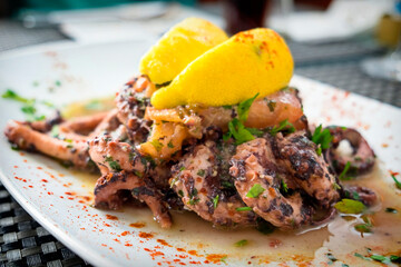 Delicious dish from traditonal cuisine of Malta island - freshly caught octopus grilled with garlic and olive oil and served with wine sauce