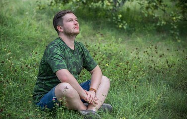 Naklejka na ściany i meble Young meditative guy at nature. People of new world, changing time