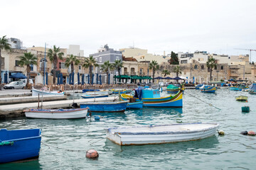 Fototapeta na wymiar The traditional maltese luzzu boats in the harbor of fishing village Marsaxlokk in Malta 