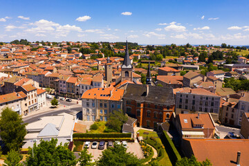 View from drone of Craponne-sur-Arzon summer cityscape with black Gothic steeple of parish church...