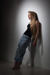 beautiful teen blonde girl in black bodysuit and jeans