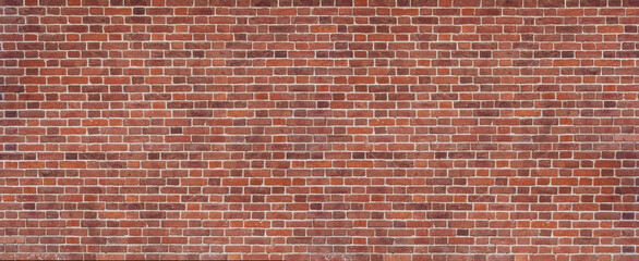 Panoramic background of wide old red and brown brick wall texture. Home or office design backdrop.