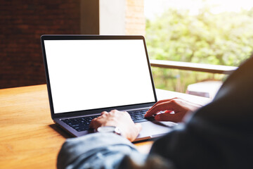Mockup image of a woman using and typing on laptop computer keyboard with blank white desktop...