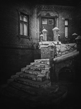 Black and white exterior architecture details, old staircase leads to the entry of the Hunting Castle at Manuc Bei mansion. Old brick building facade. Halloween haunted house concept, ghost home.