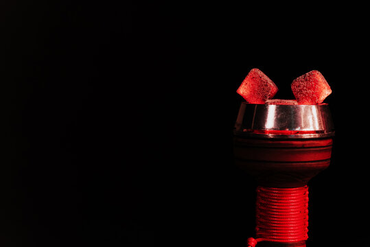 red hot coals of a hookah in a shisha bowl on a black background