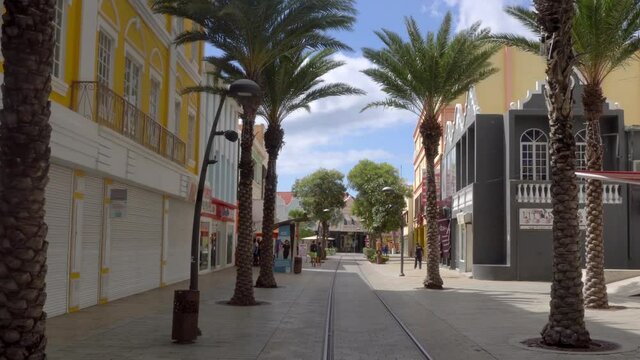 Oranjestad, Aruba / Netherlands Antilles: Main street Caya G.F. Betico Croes with famous tramway tracks, beautiful dutch colonial style architecture and palm trees