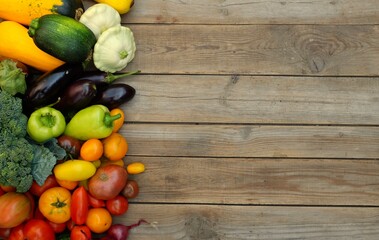 Many different bright, colorful vegetables on a wooden background. Harvest and summer season concept.