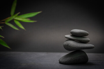 Spa zen basalt stones and green bamboo leaves on white background. The concept of wellness,...
