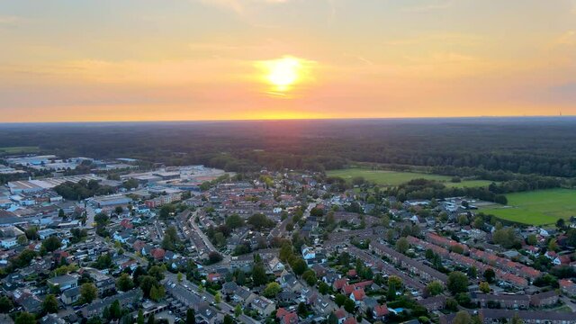 Flying over beautiful town with a orange sun setting in the background