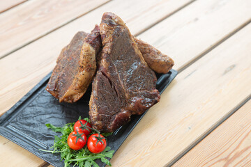 large steak from  grilled t-bone decorated with herbs  tomatoes and salt