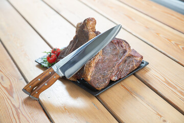 large steak from  grilled t-bone decorated with herbs  tomatoes and salt