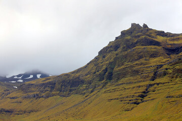 Stunning and famous Kirjkufell arrowhead mountain with blue sky and clouds in background. Daytime shot on Snaefellsnes peninsula, Iceland