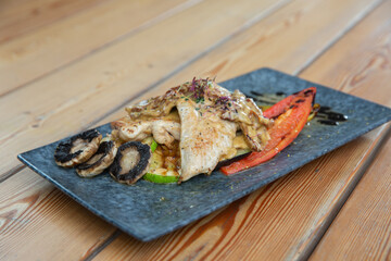 chicken with vegetables on a wooden background