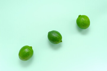 Fresh juicy bright limes on a gentle mint light background with place for text. citrus vitamin C healthy eating and minimal lifestyle. blank for postcards banner and menu