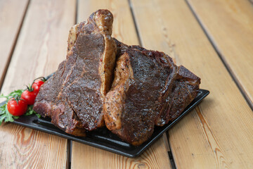 large steak from  grilled t-bone decorated with herbs  tomatoes and salt