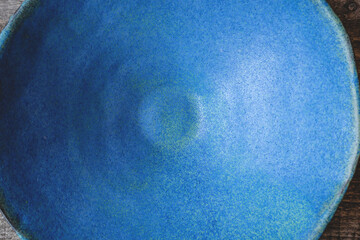 Handmade ceramics in the style of wabi sabi. Blue clay bowl with an abstract pattern. Top view.