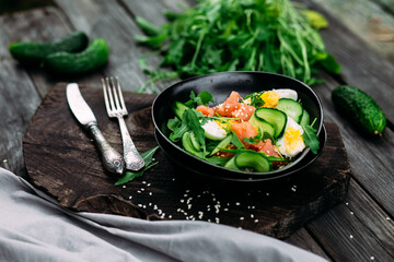 Salad with salmon, arugula, cucumber and egg