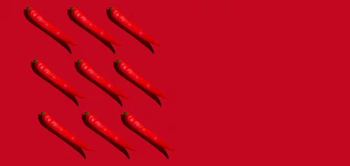 Gardinen Chilischoten Pattern of nine red hot chili peppers in hard light against red background. Copy space.  © Kirill Pataki