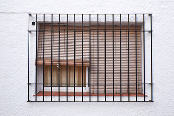 photograph of old window with bars and blind