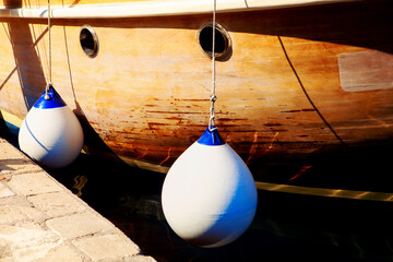 Wooden ship and bumpers for docking . Boat Fenders on the harbour 
