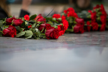 Flowers lie on a granite monument, laying flowers on the day of remembrance and mourning.