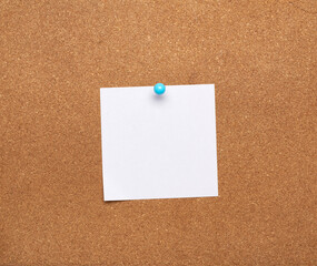 blank square white sheet of paper attached with blue button on a brown background