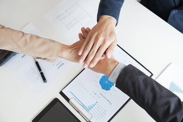 Teamwork concept, Businesspeople put hands together in meeting room.
