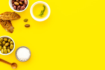 Mediterranean olives near bread on cutting board top view copy space