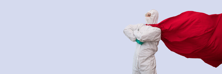 Fototapeta na wymiar A doctor in a costume of a super hero stands on defense against a viral pandemic