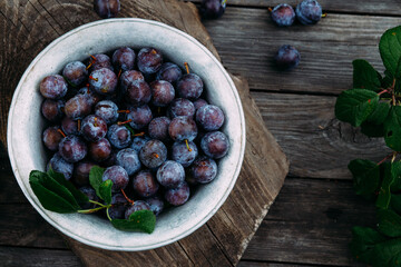 Ripe blue plum in a wooden box