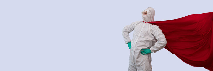 Fototapeta na wymiar A doctor in a costume of a super hero stands on defense against a viral pandemic