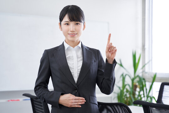 オフィスで指差しで説明をする日本人女性ビジネスウーマン