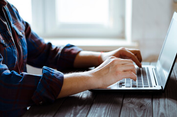 Working in the home office. Freelancer's hands on laptop keyboard