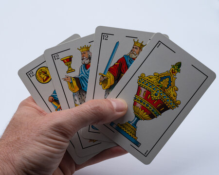 Una mano sujeta 4 cartas de la baraja española.
Buena jugada en el juego del mus, 31.
