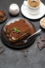 Classic tiramisu dessert, cup of coffee, sugar and milk on concrete background