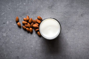Obraz na płótnie Canvas Almond milk in a glass with almond ingredients on table