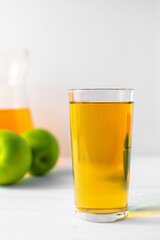 Glass of apple juice on white table. Copy space. 