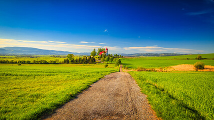 Rural landscape with a church in the background. Saint Kosmas Church in Abramova village, Turiec Region, Slovakia, Europe.