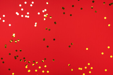 Golden confetti on red background. Happy new year celebration party. Greetings and congratulation concept. Festive backdrop with copy space for your design
