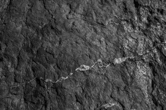 Closeup on rock rough natural mineral stone background, top view.