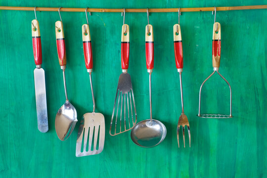 vintage kitchen utensils on grenn painted wall, free copy space