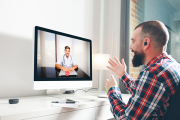 Fototapeta na wymiar Young man talking to his doctor through a video conference